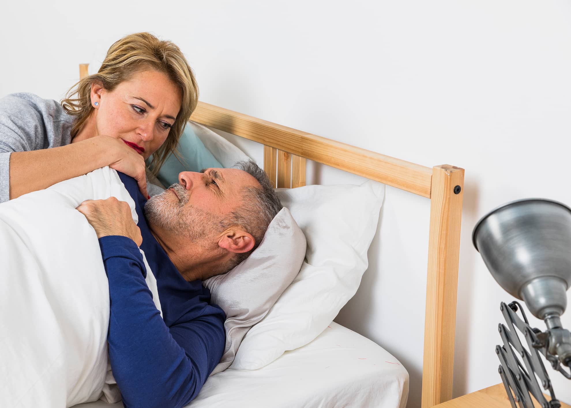Mature couple sleeping peacefully in bed after finding CPAP alternative for sleep apnea treatment